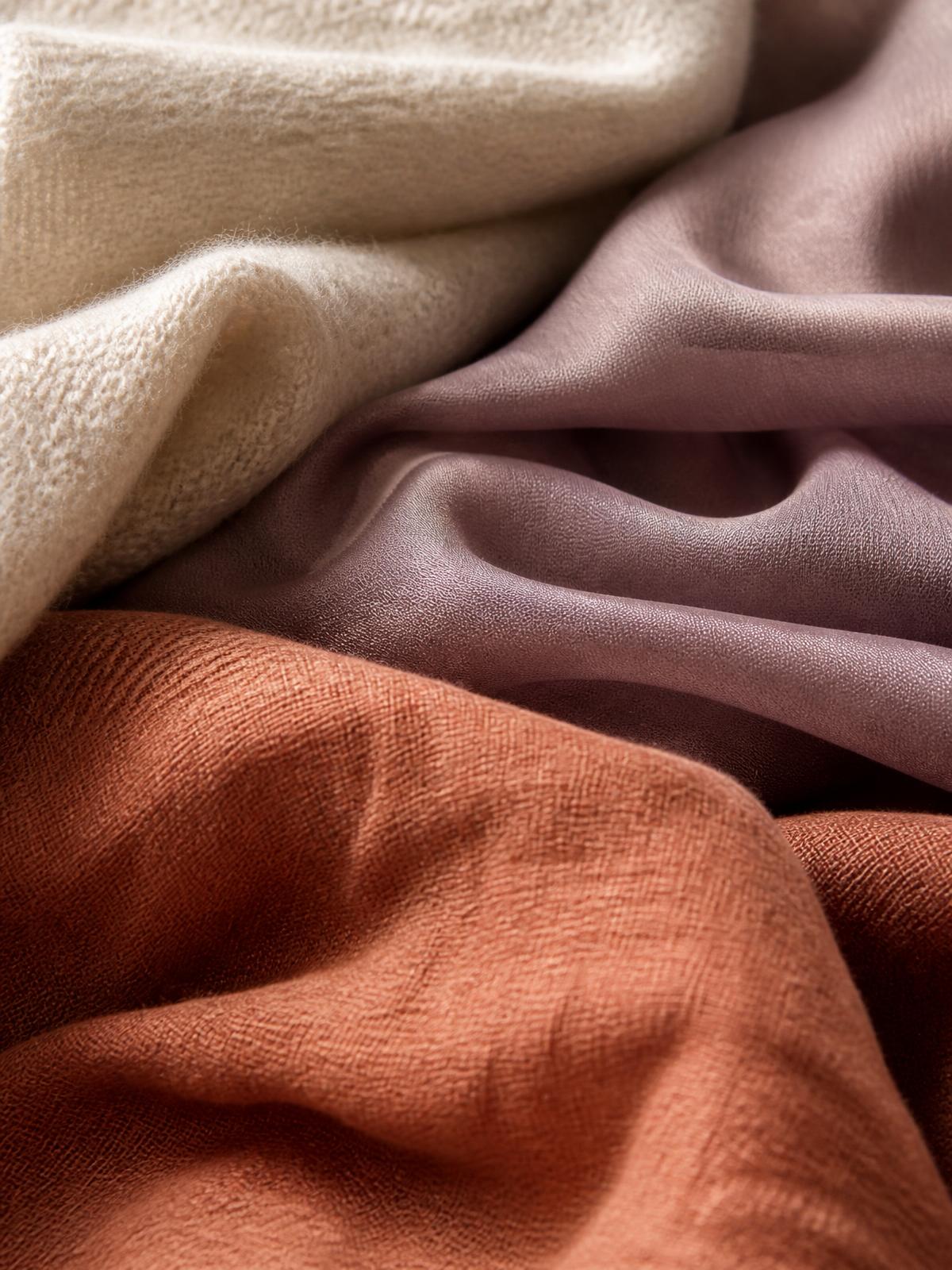 Tessuti in lana crema, seta malva e lino argilla scelti per i capi dell'atelier